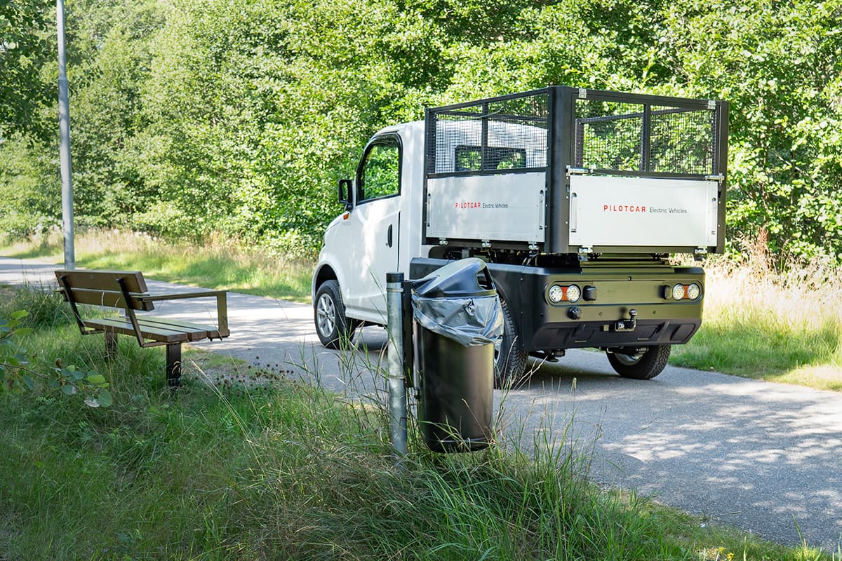 Eldrivet arbetsfordon Pilotcar med flak och grind parkerat på gångväg i parkmiljö \u2013 E-TRON AB